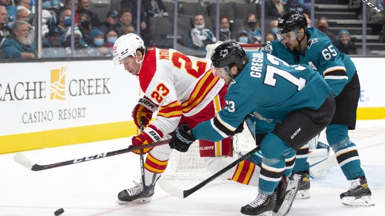 Dec 7, 2021; San Jose, California, USA; Calgary Flames center Sean Monahan (23) and San Jose Sharks center Noah Gregor (73) battle for the puck during the first period at SAP Center at San Jose. Mandatory Credit: D. Ross Cameron-USA TODAY Sports