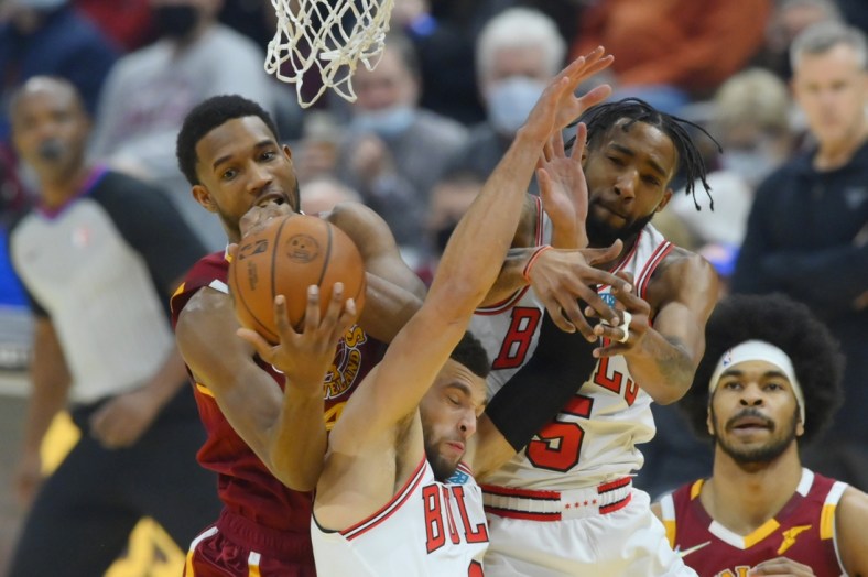 Dec 8, 2021; Cleveland, Ohio, USA; Cleveland Cavaliers center Evan Mobley (4) rebounds the ball behind Chicago Bulls guard Zach LaVine (8) and forward Derrick Jones Jr. (5) in the first quarter at Rocket Mortgage FieldHouse. Mandatory Credit: David Richard-USA TODAY Sports