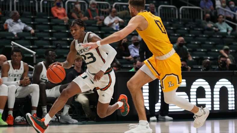Dec 8, 2021; Coral Gables, Florida, USA; Miami Hurricanes guard Kameron McGusty (23) drives the ball around Lipscomb Bisons forward Parker Hazen (13) during the second half at Watsco Center. Mandatory Credit: Jasen Vinlove-USA TODAY Sports