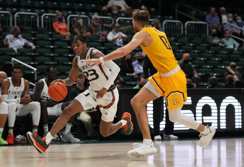 Dec 8, 2021; Coral Gables, Florida, USA; Miami Hurricanes guard Kameron McGusty (23) drives the ball around Lipscomb Bisons forward Parker Hazen (13) during the second half at Watsco Center. Mandatory Credit: Jasen Vinlove-USA TODAY Sports