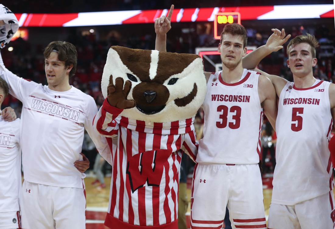 Dec 8, 2021; Madison, Wisconsin, USA; Wisconsin Badgers mascot Bucky Badger sings "Varsity" with Wisconsin Badgers center Chris Vogt (33) and Wisconsin Badgers forward Tyler Wahl (5) at the Kohl Center. Mandatory Credit: Mary Langenfeld-USA TODAY Sports