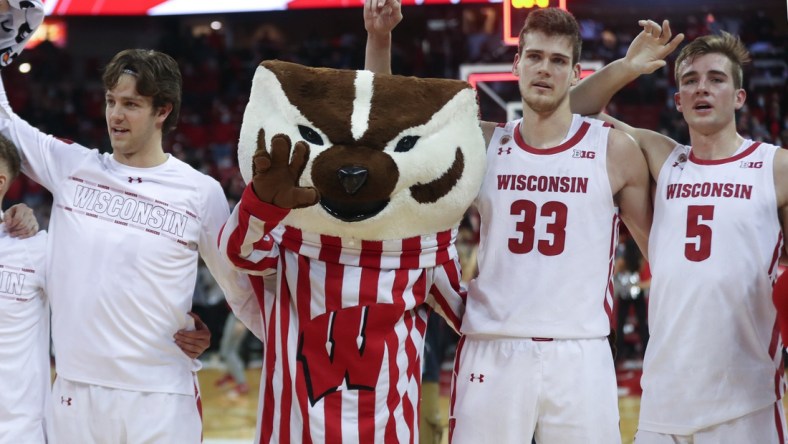 Dec 8, 2021; Madison, Wisconsin, USA; Wisconsin Badgers mascot Bucky Badger sings "Varsity" with Wisconsin Badgers center Chris Vogt (33) and Wisconsin Badgers forward Tyler Wahl (5) at the Kohl Center. Mandatory Credit: Mary Langenfeld-USA TODAY Sports