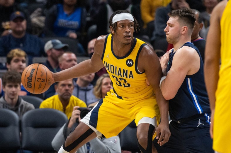 Dec 10, 2021; Indianapolis, Indiana, USA; Indiana Pacers center Myles Turner (33) dribbles the ball while Dallas Mavericks guard Luka Doncic (77) defends in the first half at Gainbridge Fieldhouse. Mandatory Credit: Trevor Ruszkowski-USA TODAY Sports