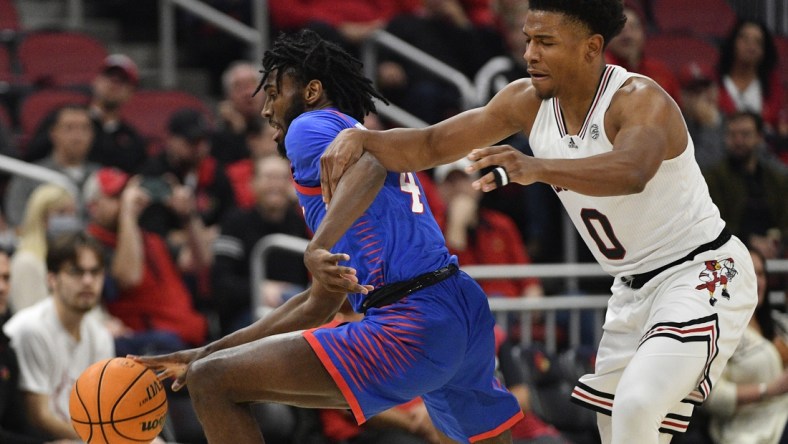 Dec 10, 2021; Louisville, Kentucky, USA;  DePaul Blue Demons guard Javon Freeman-Liberty (4) dribbles under the pressure of Louisville Cardinals guard Noah Locke (0) during the first half at KFC Yum! Center. Mandatory Credit: Jamie Rhodes-USA TODAY Sports