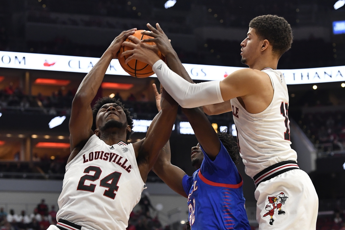 Dec 10, 2021; Louisville, Kentucky, USA;  Louisville Cardinals forward Samuell Williamson (10) and forward Jae'Lyn Withers (24) battle DePaul Blue Demons forward David Jones (32) for a rebound during the first half at KFC Yum! Center. Mandatory Credit: Jamie Rhodes-USA TODAY Sports