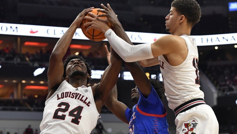 Dec 10, 2021; Louisville, Kentucky, USA;  Louisville Cardinals forward Samuell Williamson (10) and forward Jae'Lyn Withers (24) battle DePaul Blue Demons forward David Jones (32) for a rebound during the first half at KFC Yum! Center. Mandatory Credit: Jamie Rhodes-USA TODAY Sports