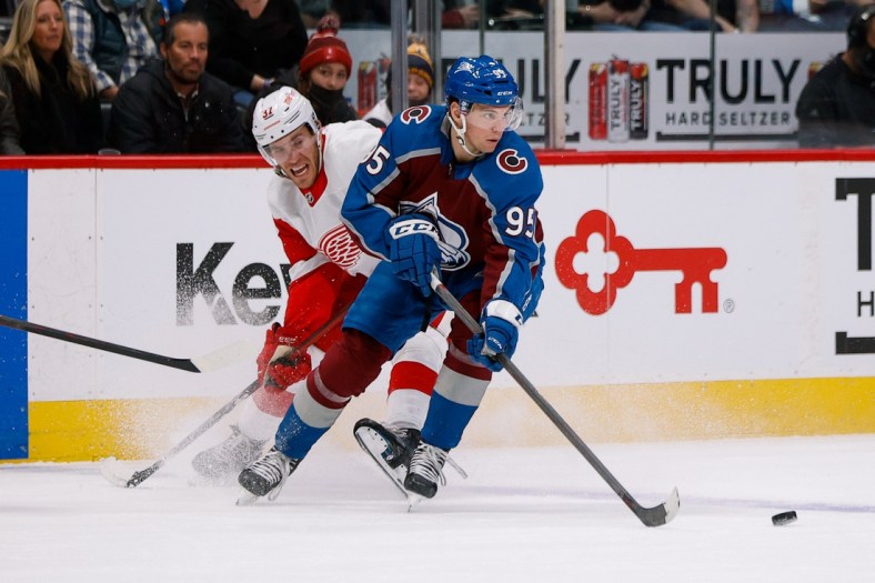 Dec 10, 2021; Denver, Colorado, USA; Colorado Avalanche left wing Andre Burakovsky (95) controls the puck under pressure from Detroit Red Wings right wing Carter Rowney (37) in the first period at Ball Arena. Mandatory Credit: Isaiah J. Downing-USA TODAY Sports
