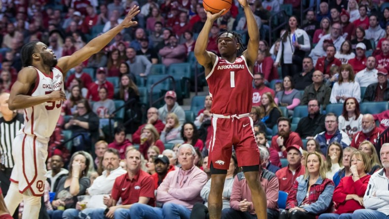 Dec 11, 2021; Tulsa, Oklahoma, USA;  Arkansas Razorbacks guard JD Notae (1) shoots the ball as Oklahoma Sooners guard Elijah Harkless (55) tries to block it during the second half at BOK Center. Oklahoma won 88-66. Mandatory Credit: Brett Rojo-USA TODAY Sports