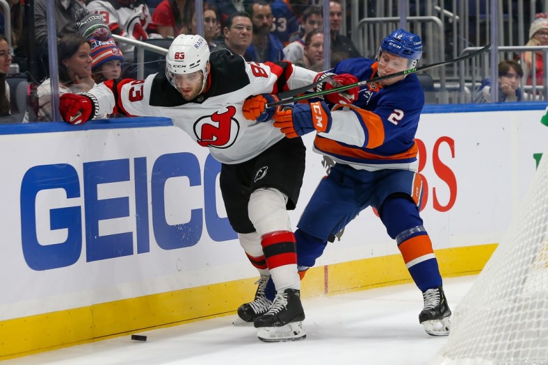 Dec 11, 2021; Elmont, New York, USA; New Jersey Devils defenseman Christian Jaros (83) and New York Islanders defenseman Robin Salo (2) battle for the puck along the boards during the first period at UBS Arena. Mandatory Credit: Tom Horak-USA TODAY Sports