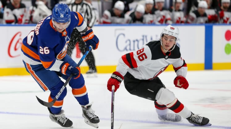 Dec 11, 2021; Elmont, New York, USA; New York Islanders right wing Oliver Wahlstrom (26) moves the puck past New Jersey Devils center Jack Hughes (86) during the second period at UBS Arena. Mandatory Credit: Tom Horak-USA TODAY Sports
