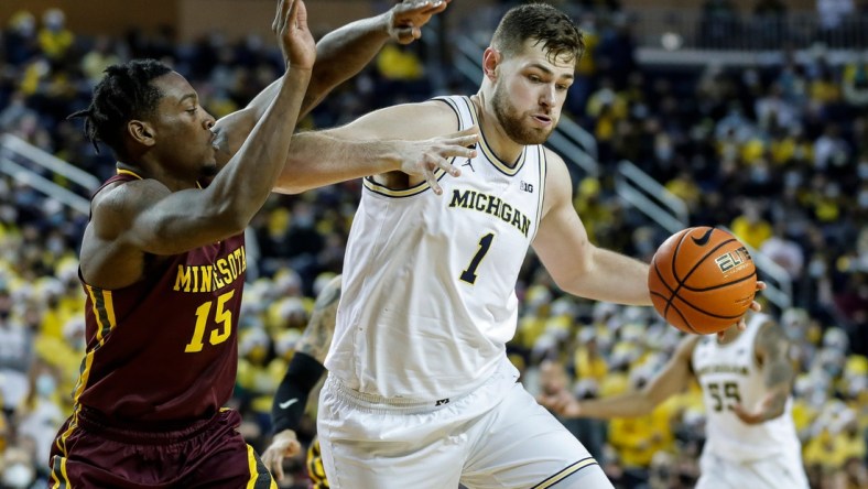 Michigan center Hunter Dickinson (1) dribbles against  Minnesota forward Charlie Daniels (15) during the second half at the Crisler Center in Ann Arbor on Saturday, Dec. 11, 2021.