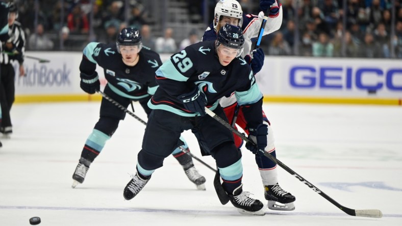 Dec 11, 2021; Seattle, Washington, USA; Seattle Kraken defenseman Vince Dunn (29) receives a pass while being defended by Columbus Blue Jackets right wing Oliver Bjorkstrand (28) during the first period at Climate Pledge Arena. Mandatory Credit: Steven Bisig-USA TODAY Sports