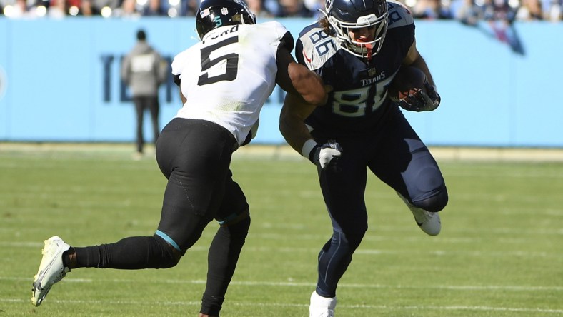 Dec 12, 2021; Nashville, Tennessee, USA;  Tennessee Titans tight end Anthony Firkser (86) runs through the tackle of Jacksonville Jaguars defensive back Rudy Ford (5) during the first half at Nissan Stadium. Mandatory Credit: Steve Roberts-USA TODAY Sports