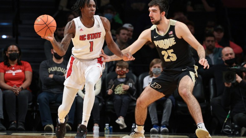 Dec 12, 2021; Brooklyn, New York, USA; North Carolina State Wolfpack guard Dereon Seabron (1) passes the ball as Purdue Boilermakers guard Ethan Morton (25) defends during the first half at Barclays Center. Mandatory Credit: Vincent Carchietta-USA TODAY Sports