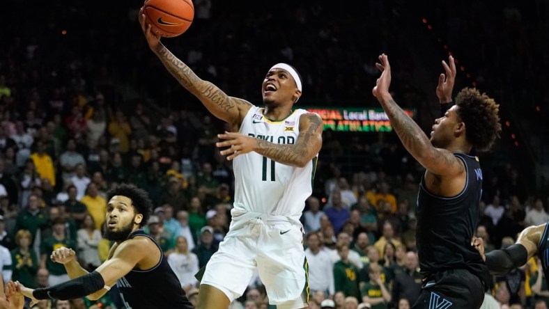 Dec 12, 2021; Waco, Texas, USA;  Baylor Bears guard James Akinjo (11) scores between Villanova Wildcats guards Justin Moore (5) and Caleb Daniels (14) during the second half at Ferrell Center. Mandatory Credit: Chris Jones-USA TODAY Sports