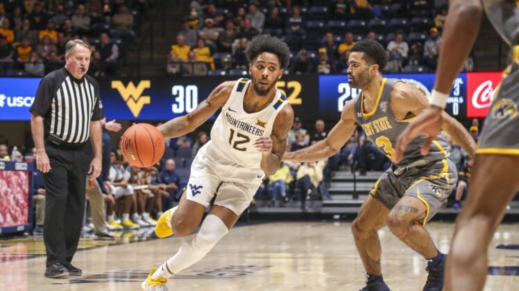 Dec 12, 2021; Morgantown, West Virginia, USA; West Virginia Mountaineers guard Taz Sherman (12) drives against Kent State Golden Flashes guard Sincere Carry (3) during the second half at WVU Coliseum. Mandatory Credit: Ben Queen-USA TODAY Sports