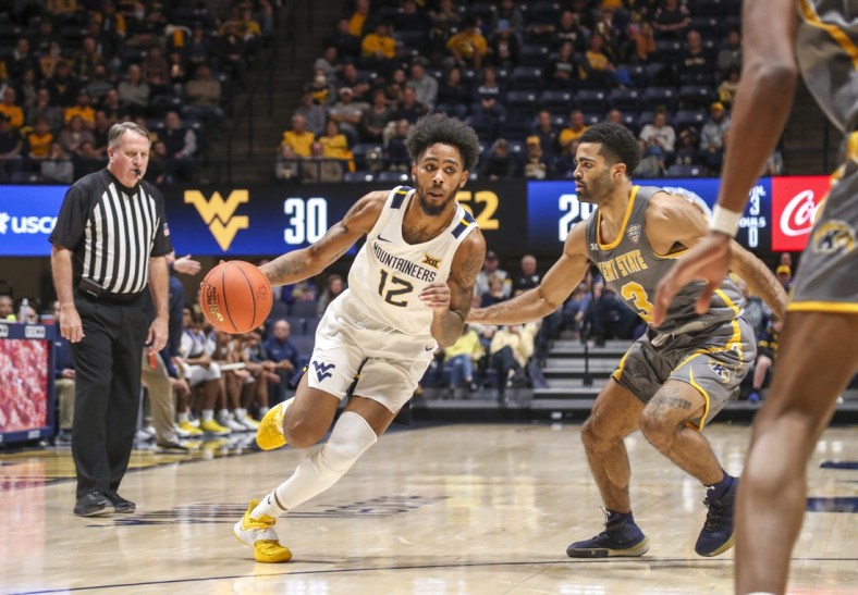 Dec 12, 2021; Morgantown, West Virginia, USA; West Virginia Mountaineers guard Taz Sherman (12) drives against Kent State Golden Flashes guard Sincere Carry (3) during the second half at WVU Coliseum. Mandatory Credit: Ben Queen-USA TODAY Sports
