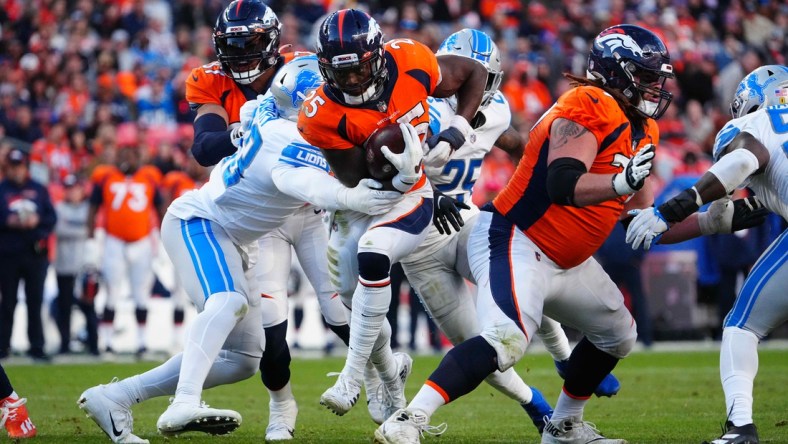 Dec 12, 2021; Denver, Colorado, USA; Denver Broncos running back Melvin Gordon III (25) carries for a touchdown past Detroit Lions linebacker Rashod Berry (43) in the third quarter at Empower Field at Mile High. Mandatory Credit: Ron Chenoy-USA TODAY Sports