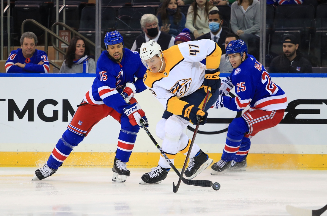 Dec 12, 2021; New York, New York, USA; Nashville Predators right wing Michael McCarron (47) fights for the puck with New York Rangers right wing Ryan Reaves (75) and New York Rangers defenseman Libor Hajek (25) during the second period at Madison Square Garden. Mandatory Credit: Danny Wild-USA TODAY Sports