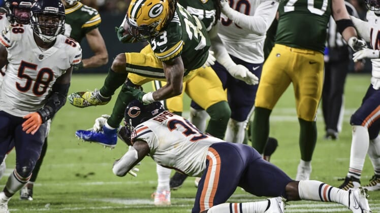 Dec 12, 2021; Green Bay, Wisconsin, USA; Green Bay Packers running back Aaron Jones (33) is tackled by Chicago Bears linebacker Trevis Gipson (99) in the second quarter at Lambeau Field. Mandatory Credit: Benny Sieu-USA TODAY Sports