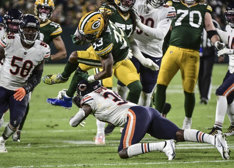 Dec 12, 2021; Green Bay, Wisconsin, USA; Green Bay Packers running back Aaron Jones (33) is tackled by Chicago Bears linebacker Trevis Gipson (99) in the second quarter at Lambeau Field. Mandatory Credit: Benny Sieu-USA TODAY Sports