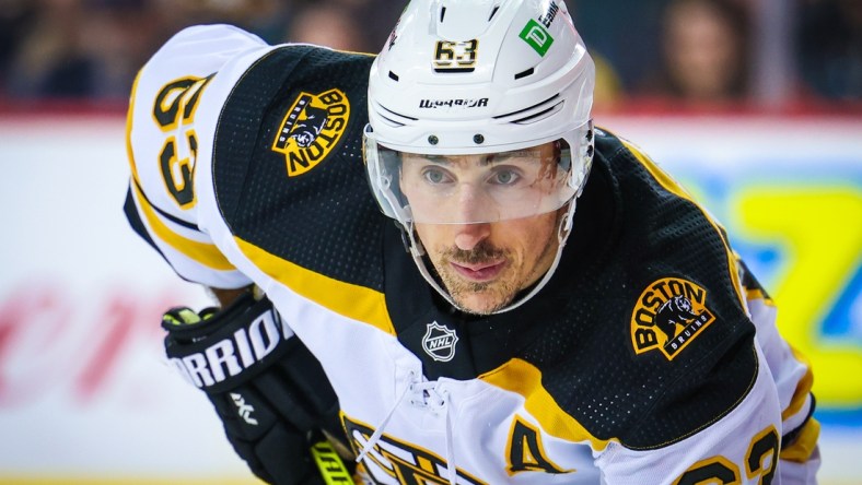 Dec 11, 2021; Calgary, Alberta, CAN; Boston Bruins left wing Brad Marchand (63) during the face off against the Calgary Flames during the second period at Scotiabank Saddledome. Mandatory Credit: Sergei Belski-USA TODAY Sports