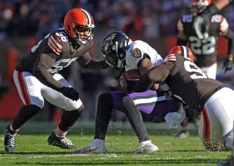 Ravens quarterback Lamar Jackson is brought down by Browns defensive end Myles Garrett (right) during the first half Sunday, Dec. 12, 2021, in Cleveland.Browns 14