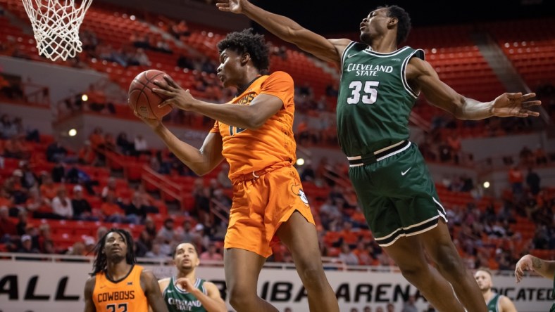 Dec 13, 2021; Stillwater, Oklahoma, USA; Oklahoma State Cowboys forward Matthew-Alexander Moncrieffe (12) shoots the ball while defended by Cleveland State Vikings forward Deante Johnson (35) during the first half at Gallagher-Iba Arena. Mandatory Credit: Rob Ferguson-USA TODAY Sports