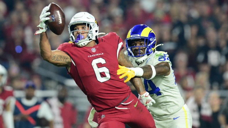 Dec 13, 2021; Glendale, Arizona, USA; Arizona Cardinals running back James Conner (6) makes a catch against Los Angeles Rams outside linebacker Leonard Floyd (54) during the first half at State Farm Stadium. Mandatory Credit: Joe Camporeale-USA TODAY Sports