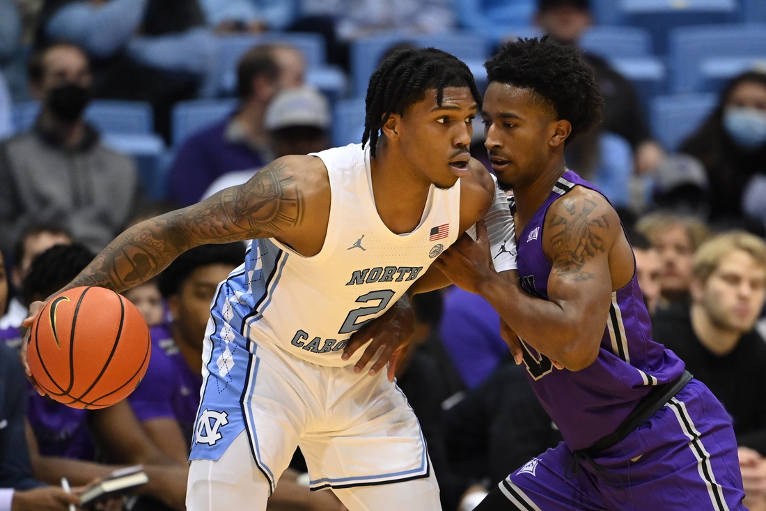 Dec 14, 2021; Chapel Hill, North Carolina, USA;  North Carolina Tar Heels guard Caleb Love (2) with the ball as Furman Paladins guard Alex Hunter (10) defends in the first half at Dean E. Smith Center. Mandatory Credit: Bob Donnan-USA TODAY Sports