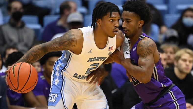 Dec 14, 2021; Chapel Hill, North Carolina, USA;  North Carolina Tar Heels guard Caleb Love (2) with the ball as Furman Paladins guard Alex Hunter (10) defends in the first half at Dean E. Smith Center. Mandatory Credit: Bob Donnan-USA TODAY Sports