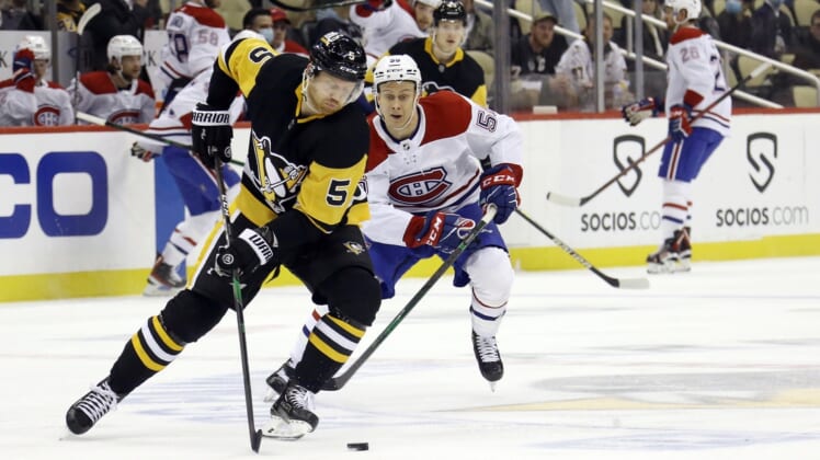 Dec 14, 2021; Pittsburgh, Pennsylvania, USA;  Pittsburgh Penguins defenseman Mike Matheson (5) handles the puck ahead of Montreal Canadiens right wing Jesse Ylonen (56) during the first period at PPG Paints Arena. Mandatory Credit: Charles LeClaire-USA TODAY Sports