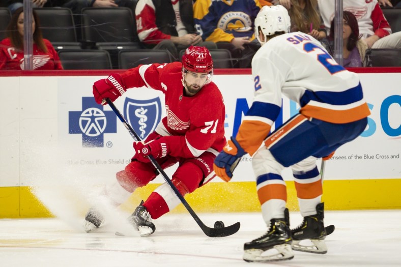 Dec 14, 2021; Detroit, Michigan, USA; Detroit Red Wings center Dylan Larkin (71) skates with the puck against New York Islanders defenseman Robin Salo (2) during the second period at Little Caesars Arena. Mandatory Credit: Raj Mehta-USA TODAY Sports
