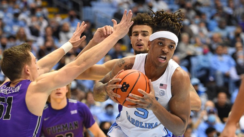 Dec 14, 2021; Chapel Hill, North Carolina, USA;  North Carolina Tar Heels forward Armando Bacot (5) with the ball as Furman Paladins guard Conley Garrison (51) and forward Jalen Slawson (20) defend in the second half at Dean E. Smith Center. Mandatory Credit: Bob Donnan-USA TODAY Sports