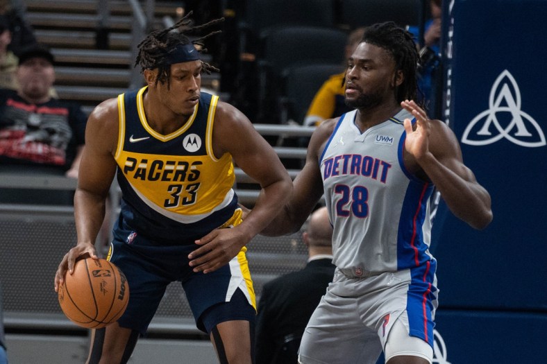 Dec 16, 2021; Indianapolis, Indiana, USA; Indiana Pacers center Myles Turner (33) dribbles the ball while Detroit Pistons center Isaiah Stewart (28) defends in the first half at Gainbridge Fieldhouse. Mandatory Credit: Trevor Ruszkowski-USA TODAY Sports