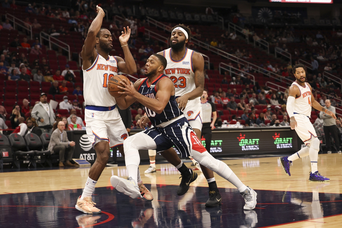 Dec 16, 2021; Houston, Texas, USA; Houston Rockets guard Eric Gordon (10) drives to the basket against New York Knicks guard Alec Burks (18) and center Mitchell Robinson (23) in the first quarter at Toyota Center. Mandatory Credit: Thomas Shea-USA TODAY Sports