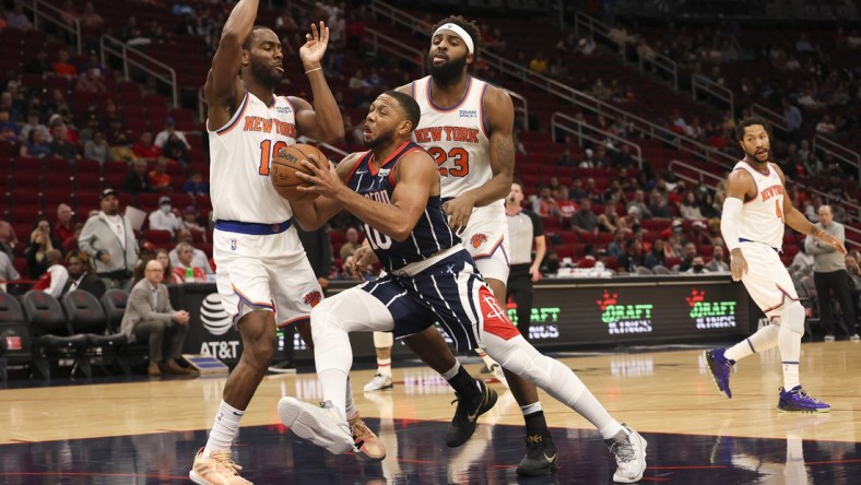 Dec 16, 2021; Houston, Texas, USA; Houston Rockets guard Eric Gordon (10) drives to the basket against New York Knicks guard Alec Burks (18) and center Mitchell Robinson (23) in the first quarter at Toyota Center. Mandatory Credit: Thomas Shea-USA TODAY Sports