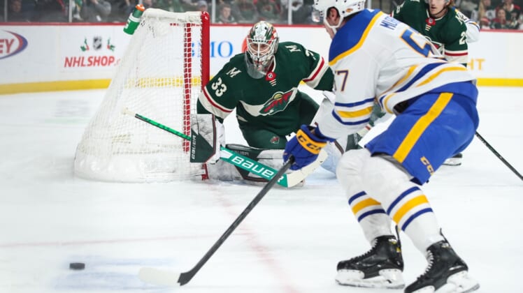 Dec 16, 2021; Saint Paul, Minnesota, USA; Minnesota Wild goaltender Cam Talbot (33) defends his net while Buffalo Sabres left wing Brett Murray (57) skates with the puck in the first period at Xcel Energy Center. Mandatory Credit: David Berding-USA TODAY Sports