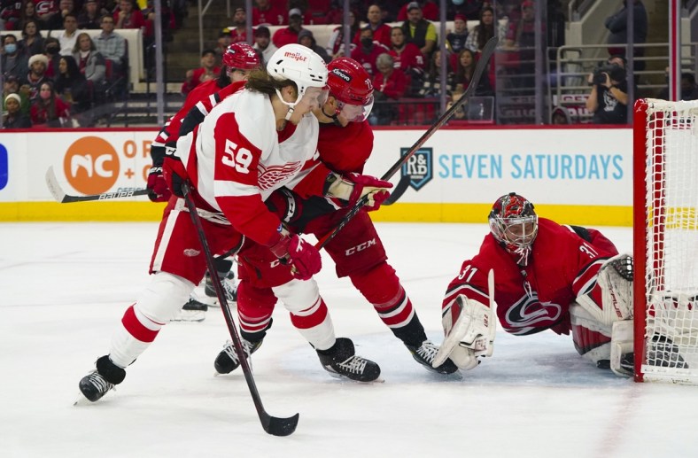 Dec 16, 2021; Raleigh, North Carolina, USA; Carolina Hurricanes goaltender Frederik Andersen (31) and defenseman Brett Pesce (22) stop the shot of Detroit Red Wings left wing Tyler Bertuzzi (59) during the second period at PNC Arena. Mandatory Credit: James Guillory-USA TODAY Sports