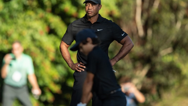 Dec 17, 2021; Orlando, Florida, USA; Tiger Woods watches son Charlie Woods play his shot from the first tee during a pro-am round of the PNC Championship golf tournament at Grande Lakes Orlando Course. Mandatory Credit: Jeremy Reper-USA TODAY Sports