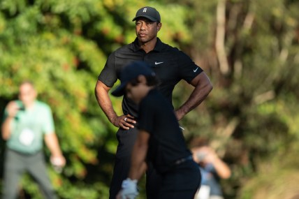 Dec 17, 2021; Orlando, Florida, USA; Tiger Woods watches son Charlie Woods play his shot from the first tee during a pro-am round of the PNC Championship golf tournament at Grande Lakes Orlando Course. Mandatory Credit: Jeremy Reper-USA TODAY Sports