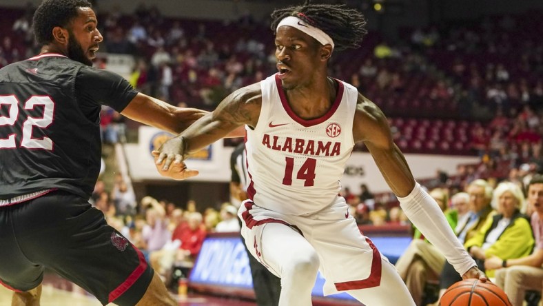 Dec 18, 2021; Tuscaloosa, Alabama, USA; Alabama Crimson Tide guard Keon Ellis (14) drives to the basket against Jacksonville State Gamecocks guard Jalen Gibbs (22) during the first half at Coleman Coliseum. Mandatory Credit: Marvin Gentry-USA TODAY Sports