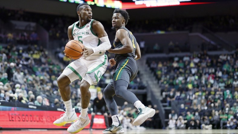 Dec 18, 2021; Eugene, Oregon, USA; Oregon Ducks guard De'Vion Harmon (5) controls the ball as Baylor Bears guard LJ Cryer (4) defends during the first half at Matthew Knight Arena. Mandatory Credit: Soobum Im-USA TODAY Sports