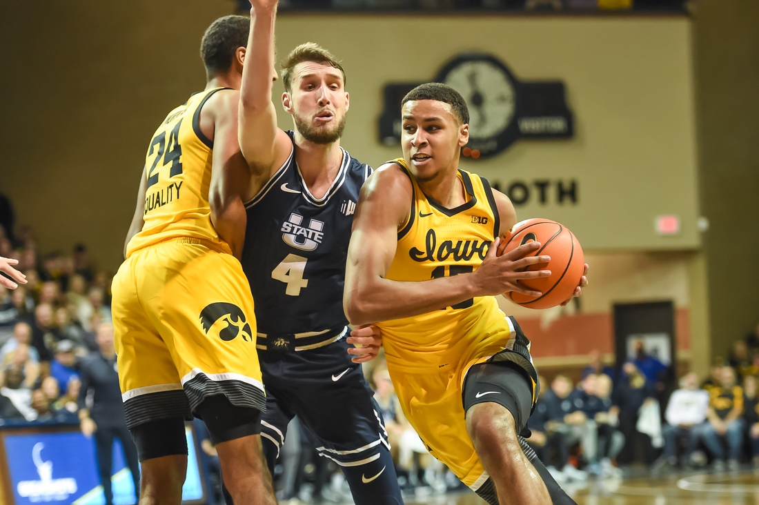 Dec 18, 2021; Sioux Falls, South Dakota, USA;  Iowa Hawkeyes forward Keegan Murray (15) drives on Utah State Aggies forward Brandon Horvath (4) in the second half at Sanford Pentagon. Mandatory Credit: Steven Branscombe-USA TODAY Sports