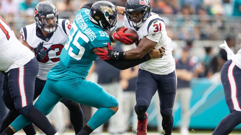 Dec 19, 2021; Jacksonville, Florida, USA; Houston Texans running back David Johnson (31) runs past Jacksonville Jaguars defensive end Roy Robertson-Harris (95) during the first half at TIAA Bank Field. Mandatory Credit: Matt Pendleton-USA TODAY Sports