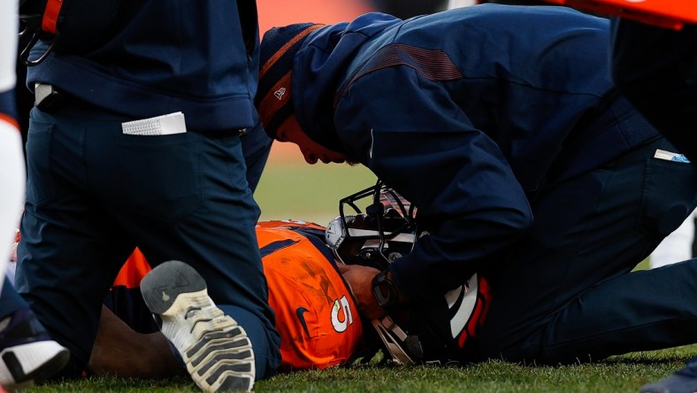 Dec 19, 2021; Denver, Colorado, USA; Denver Broncos quarterback Teddy Bridgewater (5) is tended to by personnel after a play in the third quarter against the Cincinnati Bengals at Empower Field at Mile High. Mandatory Credit: Isaiah J. Downing-USA TODAY Sports