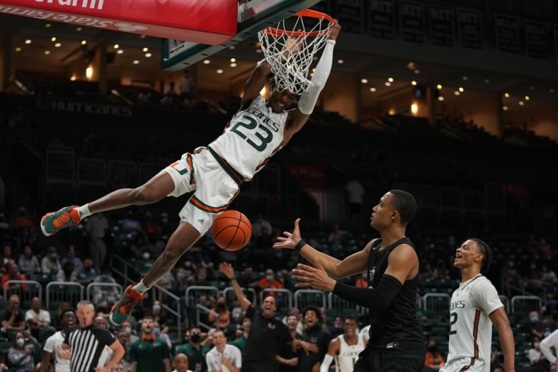Dec 20, 2021; Coral Gables, Florida, USA; Miami Hurricanes guard Kameron McGusty (23) finishes a dunk over Stetson Hatters guard Christiaan Jones (0) during the second half at Watsco Center. Mandatory Credit: Jasen Vinlove-USA TODAY Sports