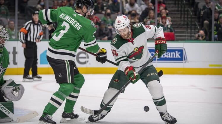 Dec 20, 2021; Dallas, Texas, USA; Dallas Stars defenseman John Klingberg (3) and Minnesota Wild right wing Ryan Hartman (38) battle for the puck during the first period at the American Airlines Center. Mandatory Credit: Jerome Miron-USA TODAY Sports