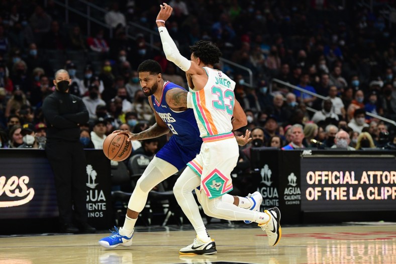 Dec 20, 2021; Los Angeles, California, USA; Los Angeles Clippers guard Paul George (13) moves the ball against San Antonio Spurs guard Tre Jones (33) during the first half at Staples Center. Mandatory Credit: Gary A. Vasquez-USA TODAY Sports