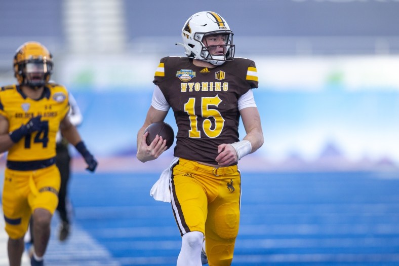 Dec 21, 2021; Boise, Idaho, USA; Wyoming Cowboys quarterback Levi Williams (15) runs the ball for a touchdown during the first half against the Kent State Golden Flashes during the 2021 Famous Idaho Potato Bowl at Albertsons Stadium. Mandatory Credit: Brian Losness-USA TODAY Sports